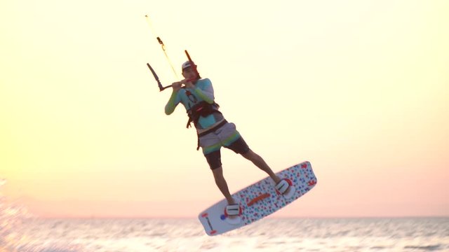 A man is jumping high in the air from the water, kitesurfing stunt, Egypt