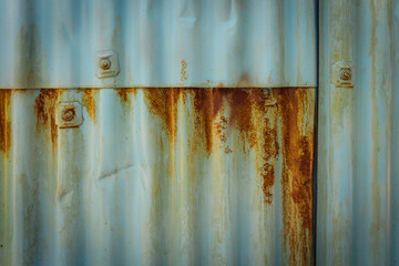 rusty and bent corrugated iron with rusty rivets