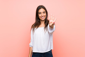 Young woman over isolated pink background happy and counting four with fingers