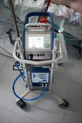 Medicine. Extracorporeal membrane oxygenation. Working ecmo machine in intensive care department. Closeup oxygenator of ECMO. Seriously ill patient on background.