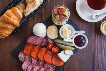 Brunch or breakfast set, meal variety with boil egg, salami, meat and cheese variety, granola, smoothie, fruits and berries. Served with bread and a cup of tea
