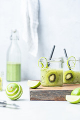 Green kiwi, lime and cucumber smoothie on white background