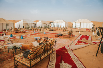 Beautiful desert camp courtyard at sunset, with carpets and seat, forming a square.