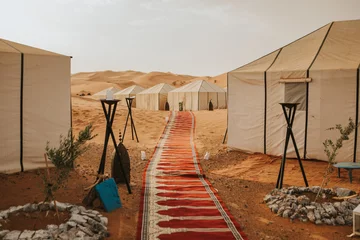 Papier Peint photo Lavable Maroc Beau camp désertique et tapis formant un couloir avec des tentes en arrière-plan.