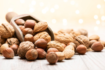 variety of nuts with wooden scoop on table