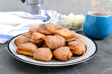 Tasty curd cheese cookies on a plate. Goose foot cookies. Homemade cakes and coffee for breakfast.