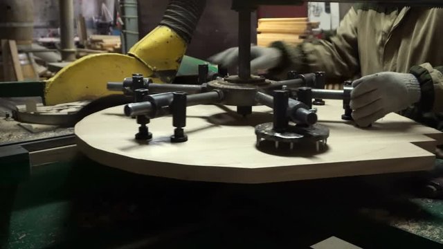 Making a wooden lid for a wine barrel on a modern woodworking machine in a cooper