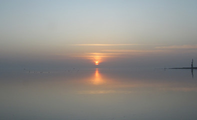 mirror reflection of the sunset of the sun in the sea