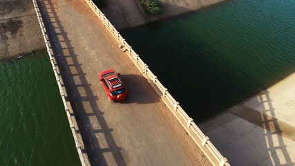 orange car on river bridge