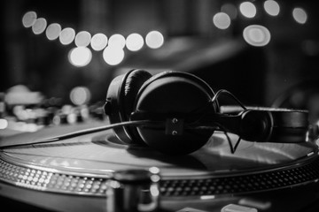 DJ headphones on a vinyl player in a dark nightclub, selective focus