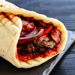 Doner kebab (shawarma or doner wrap). Grilled chicken on lavash (pita bread) with fresh vegetables. Middle Eastern food, arabic fast food