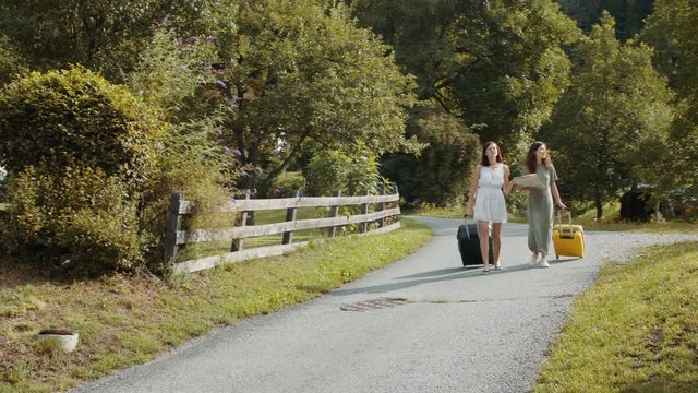 girlfriends with suitcases using paper map