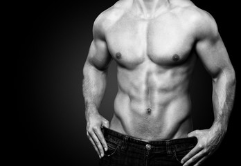 Fototapeta na wymiar Muscular torso of young man in underwear on dark background