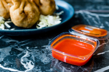 Hot Spicy Red Sriracha Sauce in Plastic Box / Package or Container for Fast Food Ready to Eat.