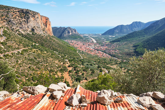 Leonidio village and impressive, tall, red limestone walls as seen from Aresos climbing sector, a climbing crag with one of the best views over Leonidio and the sea in Arcadia, Peloponnese, Greece.