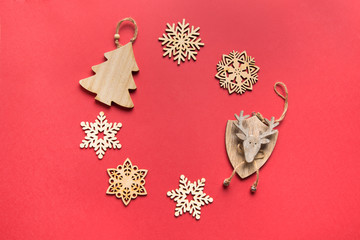 Christmas composition of wooden handmade decor as wreath on red background. Flat lay, top view, copy space. Xmas card.
