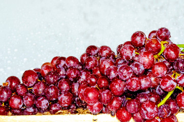 Grapes wash clean water in a wooden tray