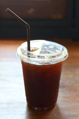 Black coffee with ice on table in cafe.