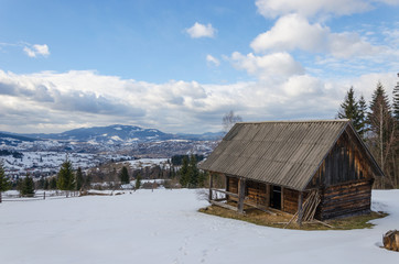 old decrepit wooden building in snow-covered mountains.