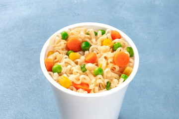 Ramen cup close-up, instant soba noodles in a plastic cup with vegetables