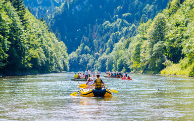 Traditional rafting on the Dunajec River on wooden boats. The rafting is very popular tourist attraction in Pieniny National Park - obrazy, fototapety, plakaty