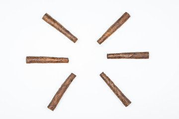 The sun laid out of twisted cigars on white background.