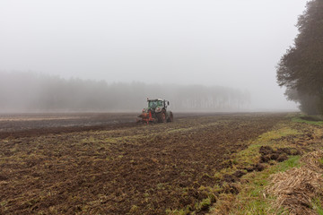 Landwirtschaft in der kalten Jahreszeit Traktor pflügt im Morgennebel Herbstwetter Herbstmorgen...