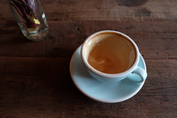 Cappuccino or latte with frothy foam, blue coffee cup top on wooden coffee shop background