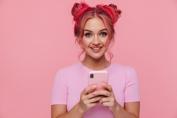 Portrait of positive young woman in t-shirt smiling and holding cellphone