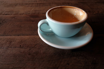 Cappuccino or latte with frothy foam, blue coffee cup top on wooden coffee shop background