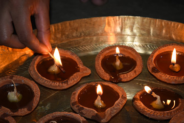 Giving flame to diyas on diwali festival in India