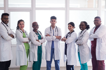 team of young doctors, mixed race. People of different sex, in white coats, with phonendoscopes, posing, smiling