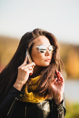 Woman with charm talking on the phone - long dark hair and sunglasses - confident independent brunette girl