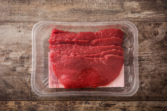 Fillet steak meat packaged in plastic on wooden background