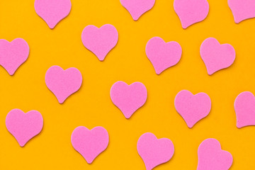 top view pink hearts pattern on a vibrant yellow background
