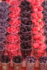 berries in plastic glasses. Fresh strawberries, raspberries, blackberries, blueberries in takeaway cups. market.