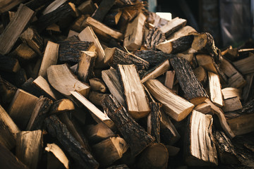 Pile of firewood on a heap. Coniferous and deciduous stacks of firewood. 