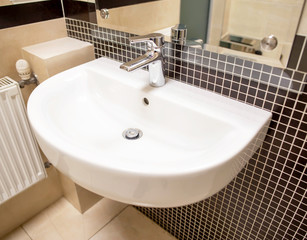 Stylish modern washbasin with black tiles on the wall, bathroom, interior