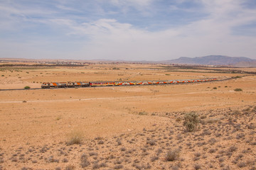 Fototapeta na wymiar Passenger train in wide desert landscape