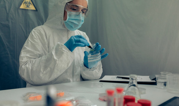 Female scientist analyzing samples contaminated with virus in a laboratory