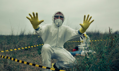 Man with bacteriological protective suit prohibiting entering cordoned off area while his partner...