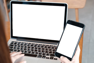 mockup image computer,cell phone blank screen for hand typing text,using laptop contact business searching information in workplace on desk at office.design creative work space on wooden desk