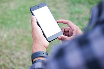 Cropped shot view of man hands holding smart phone with blank copy space screen for your text message or information content, female reading text message on cell telephone during in urban setting. 