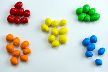 colorful candies arranged in a handful by colors
