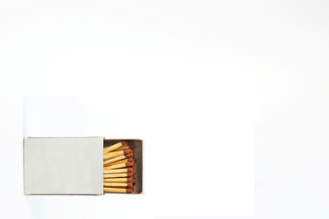  open box of wooden matches lies on its side against a white background