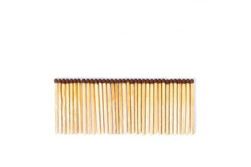 wooden matches lie in a row on a white background top view