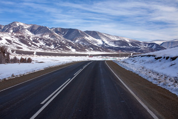 A picturesque mountain road extending into the mountains into the distance.