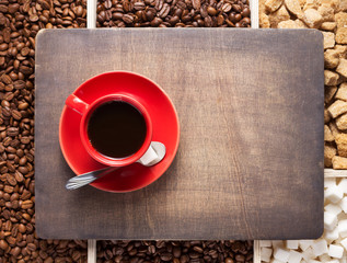 cup of coffee and beans on wooden tray