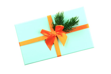 Christmas gift box blue. Orange ribbon. Spruce branch. White background. Top view.