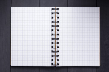notepad or notebook at black wooden background surface table, top view